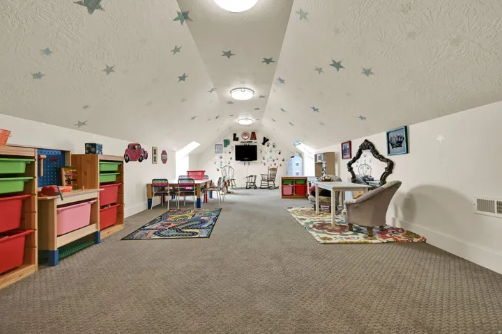 Sloped ceilings with recessed lighting, integrated skylights, and wall-to-wall carpeting