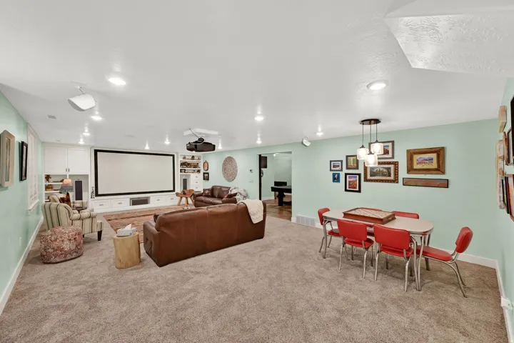 Spacious living area featuring a media screen, built-in cabinetry, recessed lighting, and carpeting