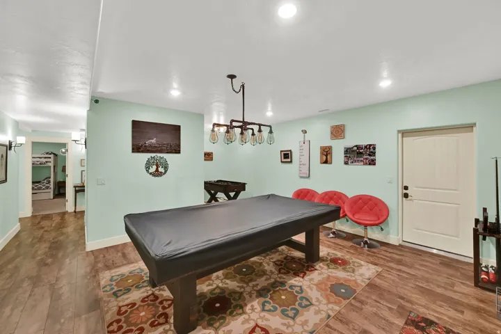 Recessed lighting, wood-finish flooring, and a decorative light fixture with exposed bulbs