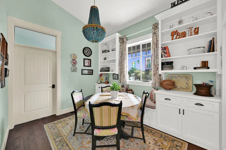 Built-in shelving with lower cabinetry, wood-finish flooring, and a transom window above a paneled door