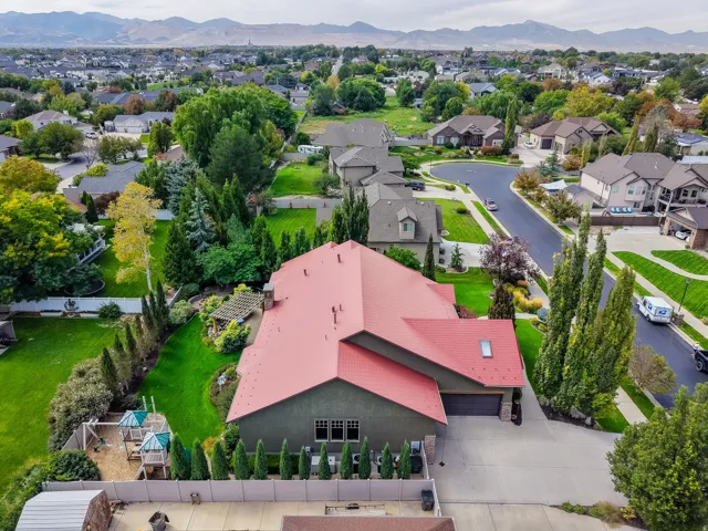 Expansive property with a red roof, a two-car garage, and a lush green lawn