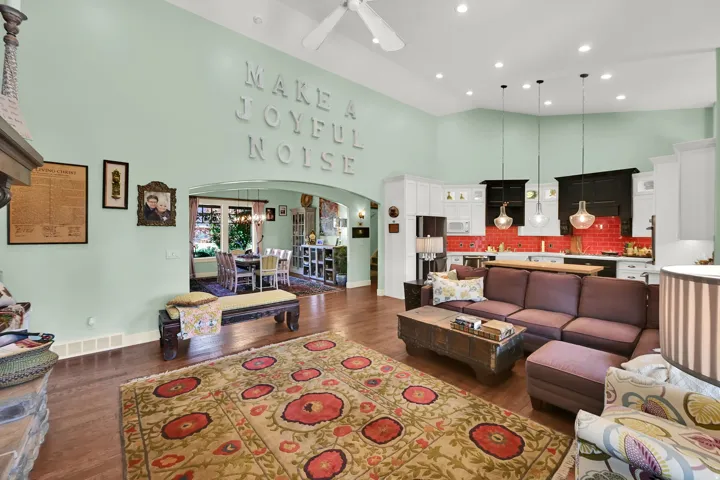 Vaulted ceiling with a ceiling fan, wood-finish flooring, recessed lighting, white cabinetry, and a red tile backsplash
