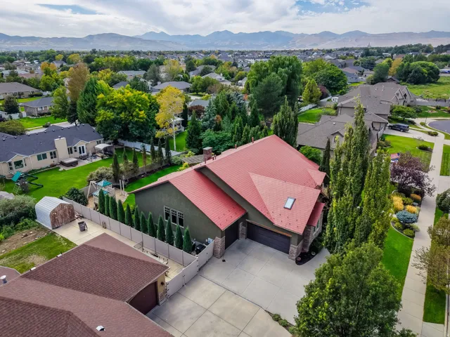 Property featuring a red-toned roof, skylight, and an attached two-car garage