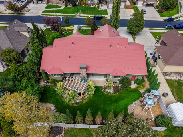 Distinctive residence showcasing a striking salmon-pink metal roof with multiple peaks and architectural angles