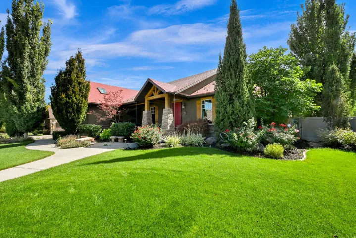 Expansive front yard with a curved concrete pathway and mature landscaping