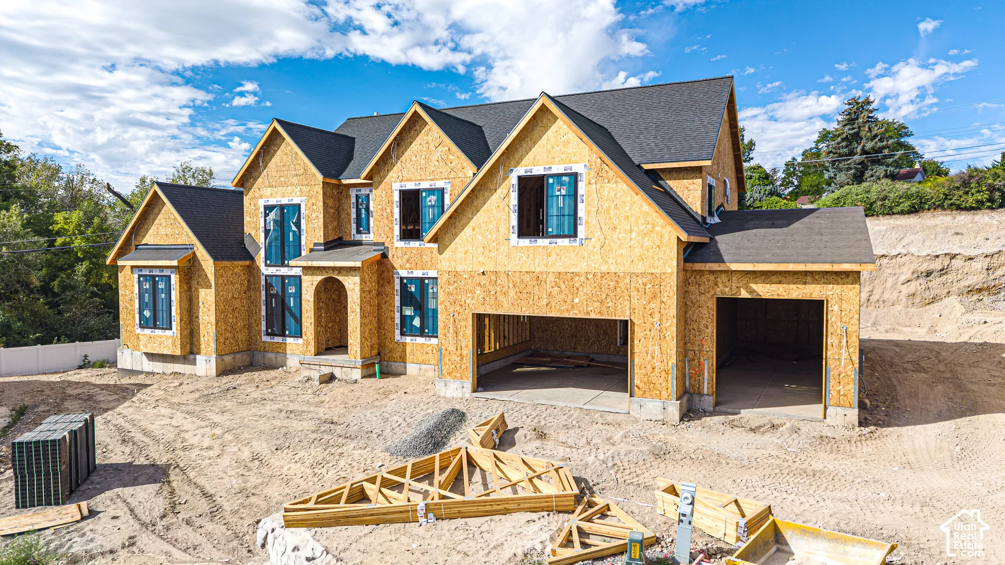 Newly constructed residence featuring a multi-gable roofline, bay window with multiple panes, arched entry, and a two-car garage