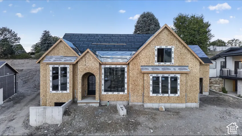 New construction featuring a multi-gabled roofline, arched entryway, and dark-framed windows