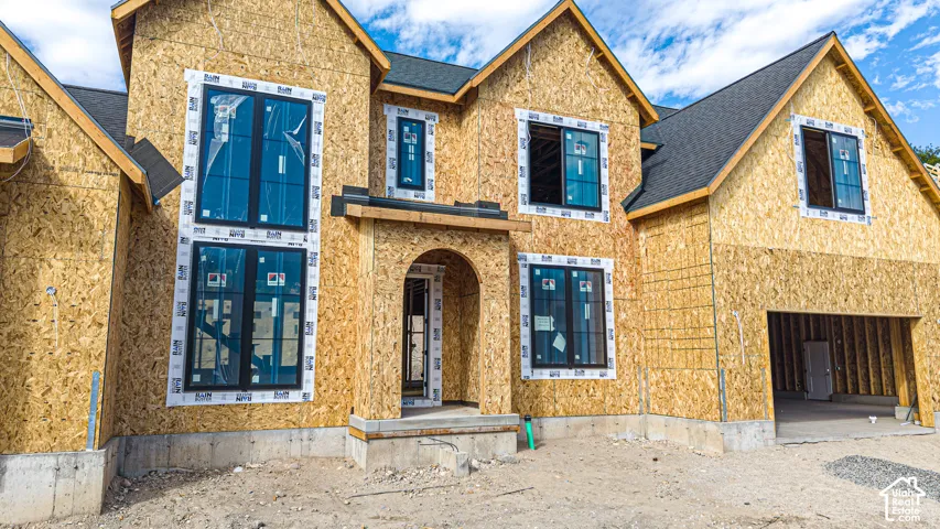Newly constructed residence featuring a two-car garage, multiple gables, and a prominent arched entryway