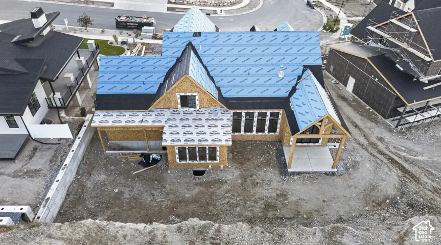 New construction residence featuring a multi-gabled roofline, timber-frame covered patio, and multiple large-format windows