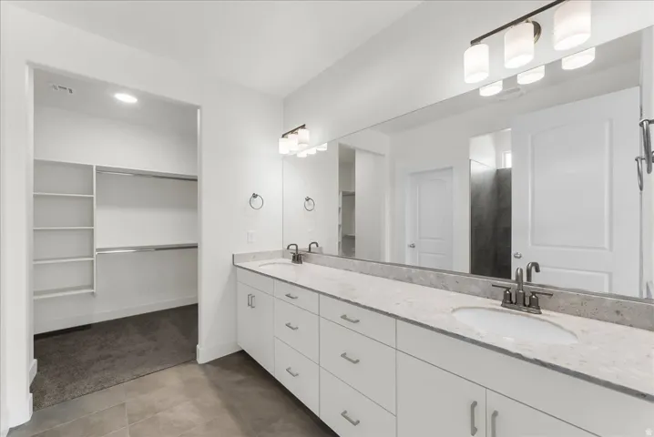 Dual vanity with white cabinetry, integrated sinks, and polished chrome fixtures