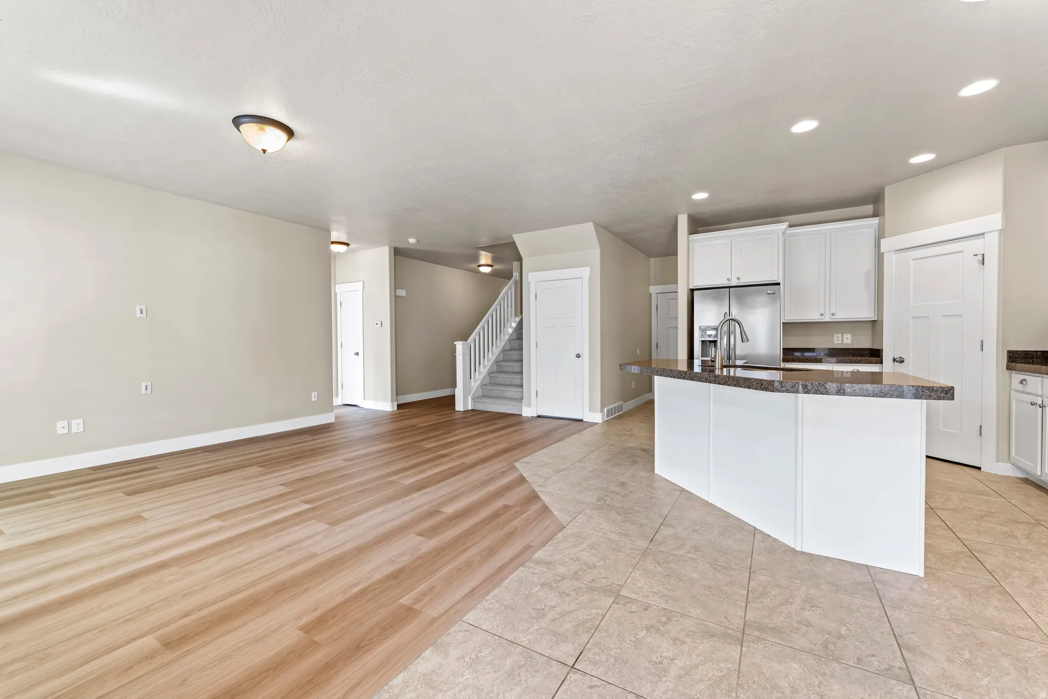 Kitchen featuring white cabinetry, stainless steel appliances, a breakfast bar, and tile flooring
