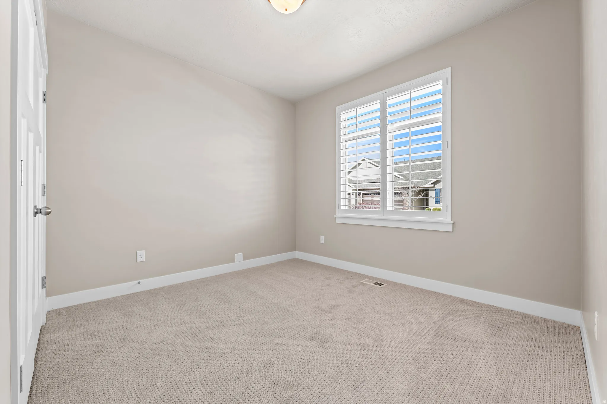 Neutral-toned wall paint, white trim, and light-colored carpeting