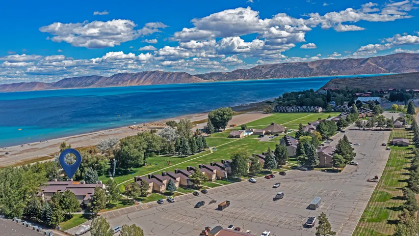 Coastal setting with expansive water frontage, mature landscaping, and a large parking area