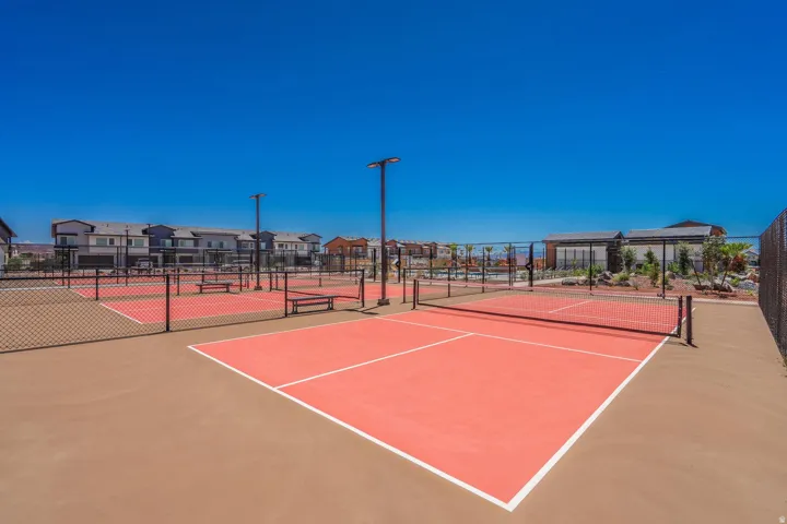 Multiple outdoor courts with surface lines, perimeter fencing, and integrated lighting