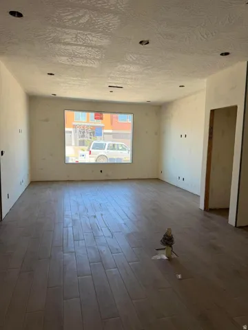 Recessed lighting, textured ceiling, tile flooring, and a large window