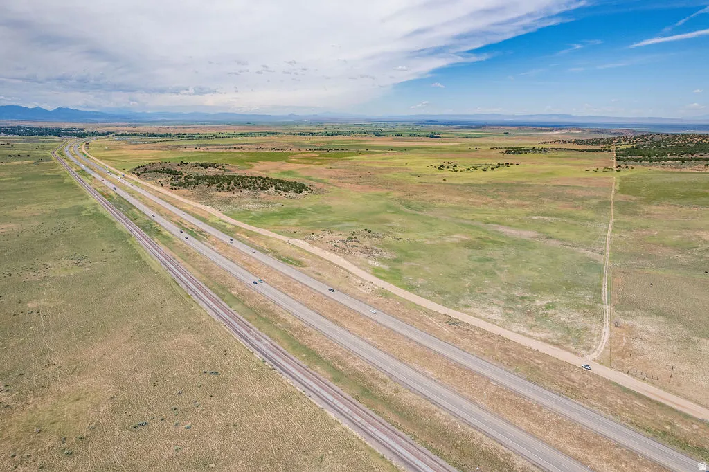 Expansive acreage featuring a multi-lane highway, railway lines, and distant mountain ranges