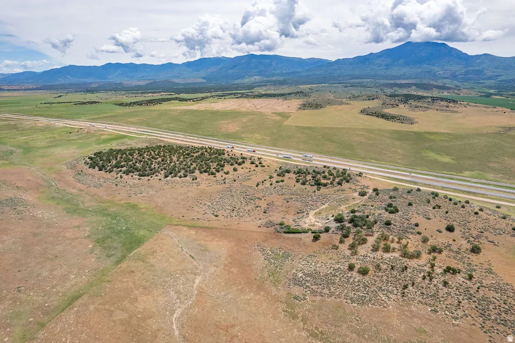 Expansive land parcel featuring natural shrubbery and distant mountain backdrops