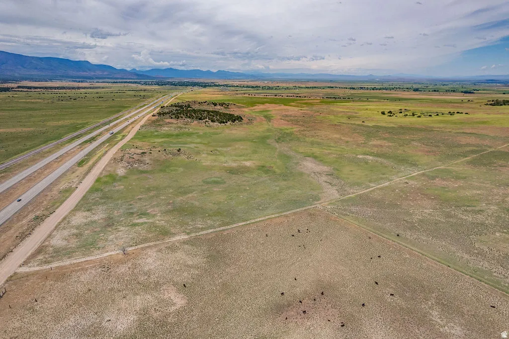 Expansive open land with distant mountains and a multi-lane highway