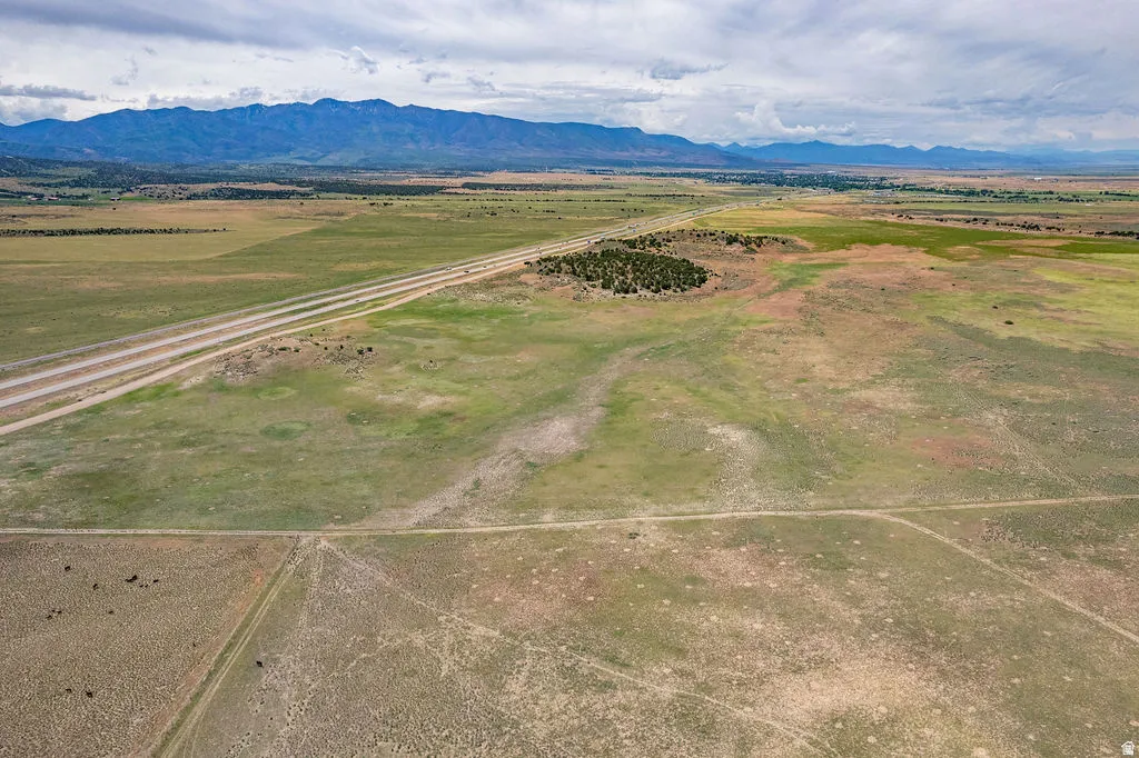 Expansive undeveloped acreage featuring multiple roadways, natural vegetation, and distant mountain ranges
