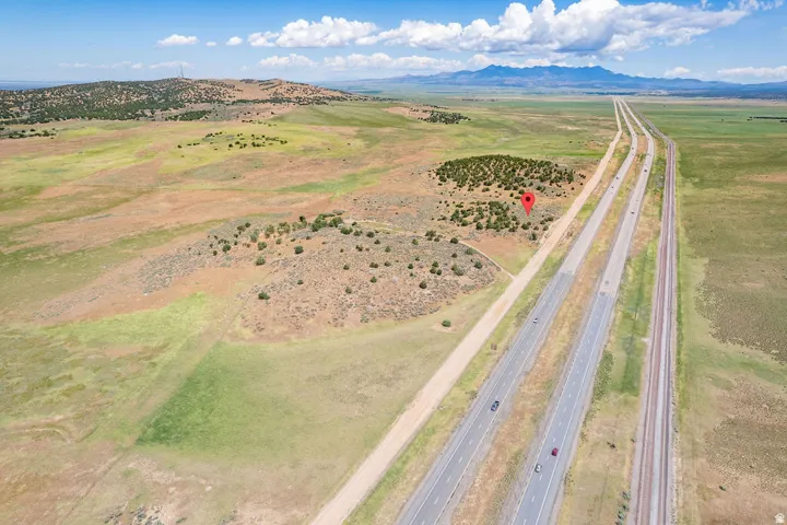 Expansive natural landscape featuring a paved highway and railroad tracks, with distant mountains