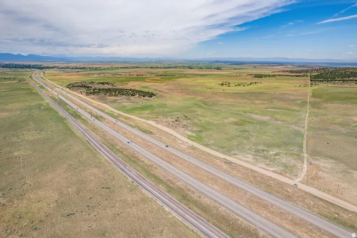 Expansive acreage featuring a multi-lane highway, railway lines, and distant mountain ranges