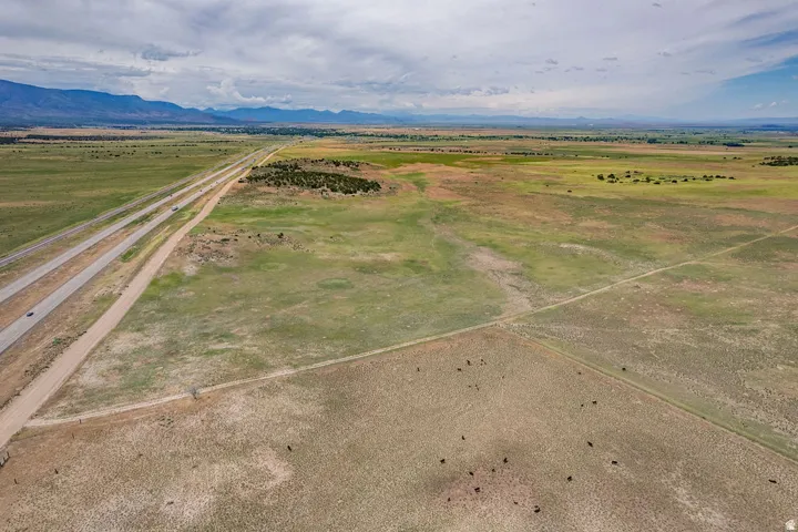 Expansive open land with distant mountains and a multi-lane highway