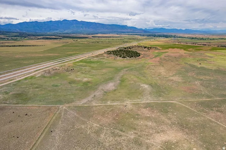 Expansive undeveloped acreage featuring multiple roadways, natural vegetation, and distant mountain ranges