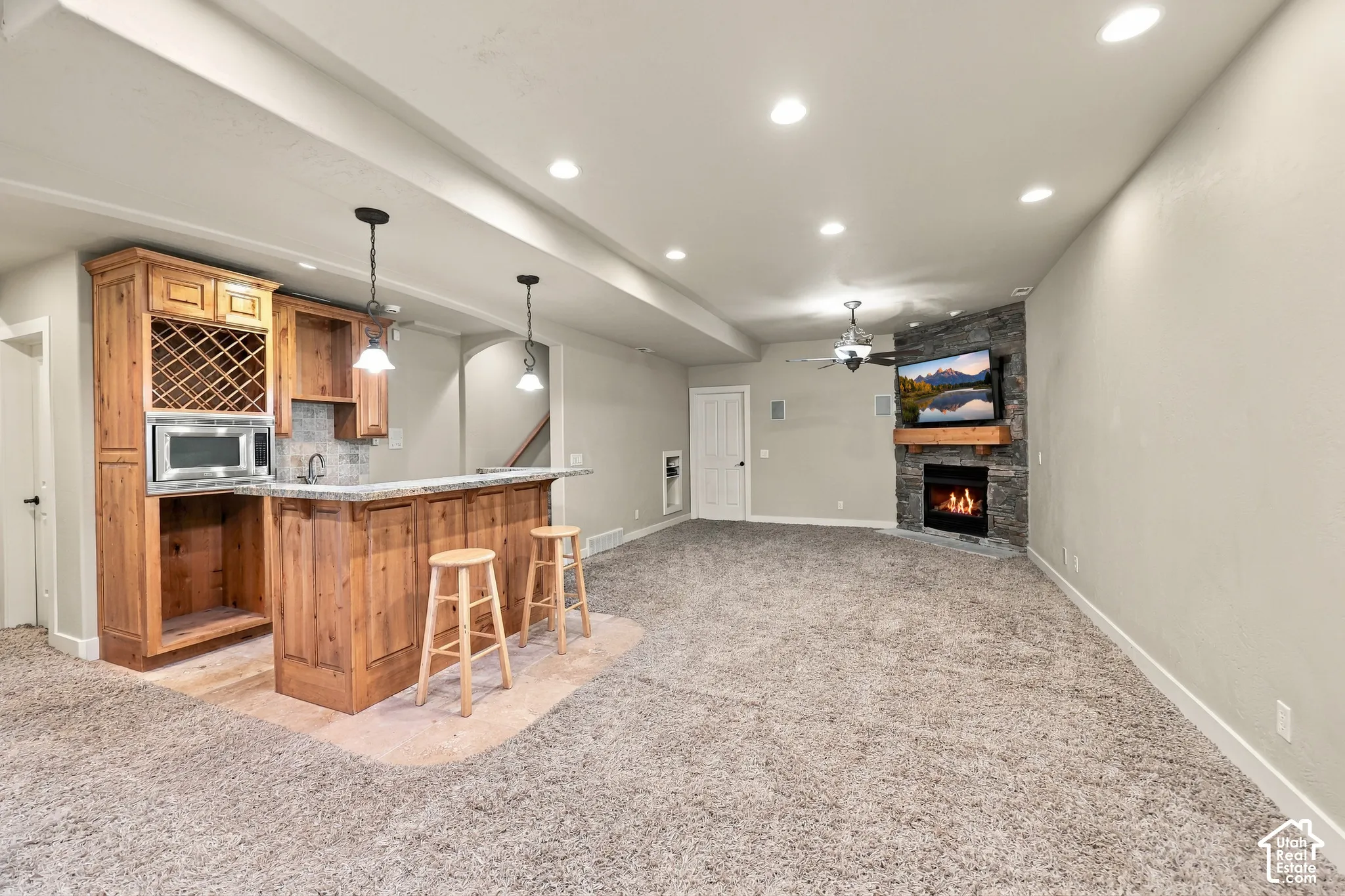 Built-in wet bar with wood cabinetry and stone-finish countertop