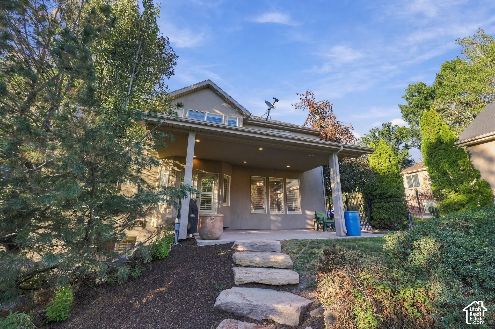 Covered patio with integrated lighting, multiple windows, and a stone-step pathway