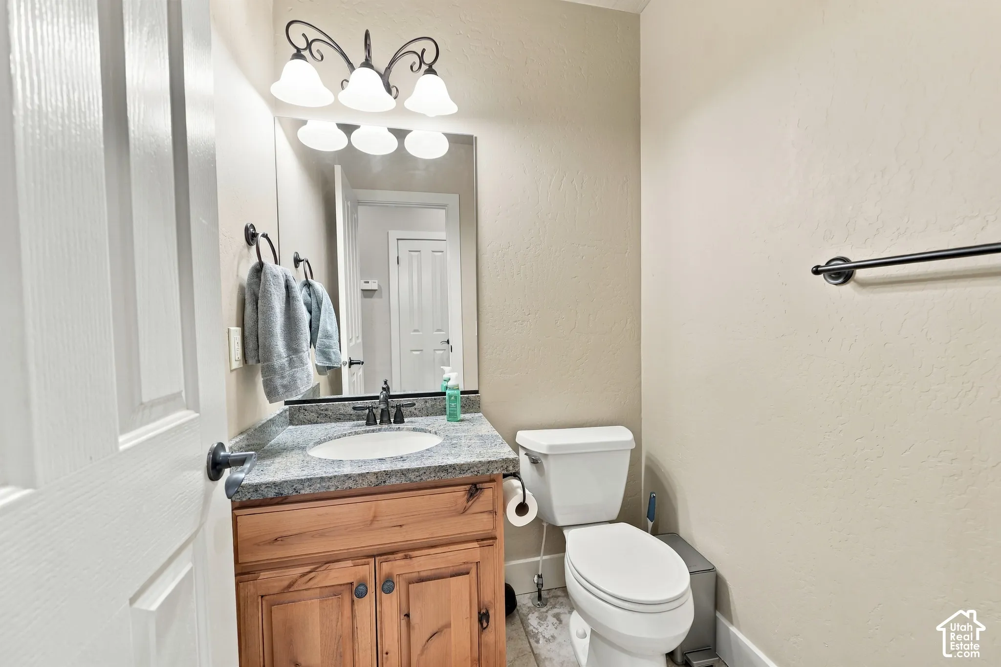 Wood-finish vanity with a granite-style countertop and undermount sink