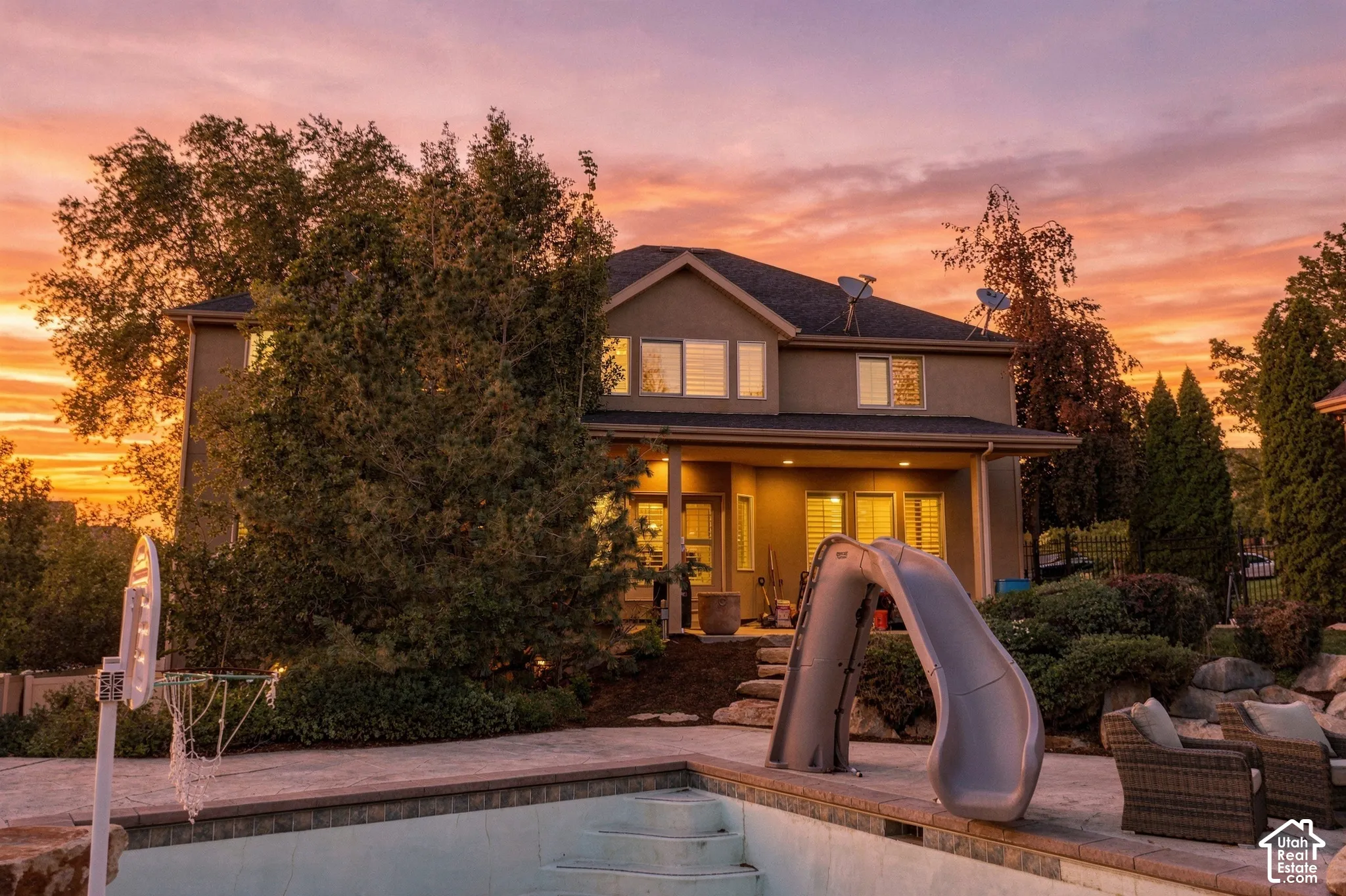 Backyard featuring a built-in pool, pool slide, and stone coping