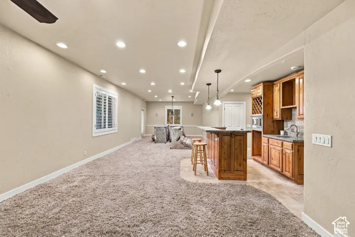 Recessed lighting, wood-finish cabinetry, built-in wine storage, stone-finish countertops, and plantation shutters