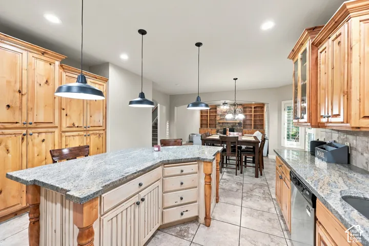 Kitchen featuring a granite-topped island with beadboard paneling, recessed lighting, and pendant fixtures