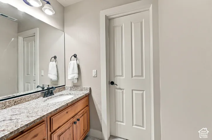 Light-toned cabinetry with dark hardware, a spacious countertop with a built-in sink, and a large wall-mounted mirror