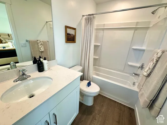 White vanity with a single basin sink and a light-colored countertop