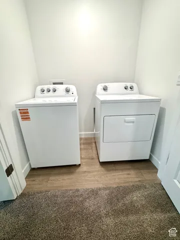 Dedicated laundry area featuring a white top-load washing machine and a white front-load dryer
