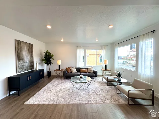 Spacious living area featuring wood-finish flooring, recessed lighting, and expansive windows