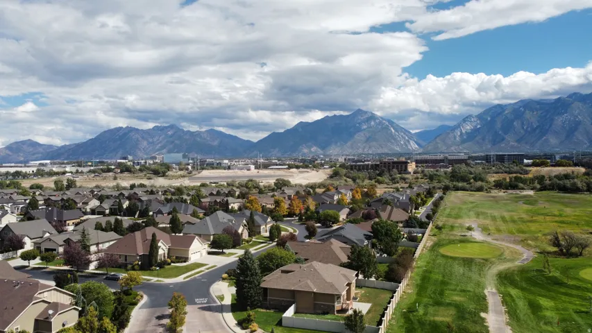 Expansive mountain backdrop with a residential community, green space, and varied rooflines