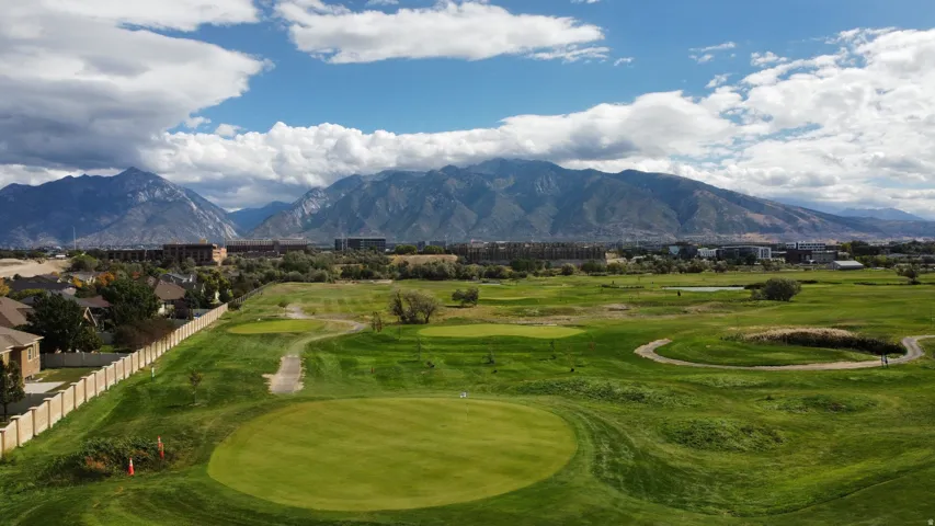 Expansive golf course setting featuring manicured greens and surrounding landscaping