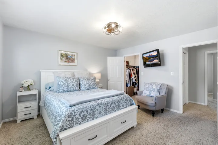 Soft grey wall paint with a built-in closet, neutral carpet flooring, and a contemporary ceiling fixture