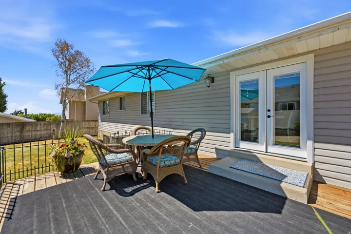 Hardscaping with a deck, concrete steps, and a metal fence