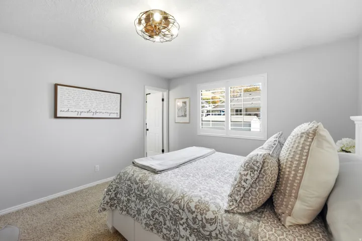 Recessed ceiling lighting, white plantation shutters, and light-colored carpeting