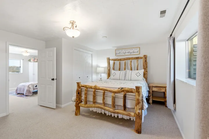 Light-colored carpeting, white paneled doors, and a double-door closet