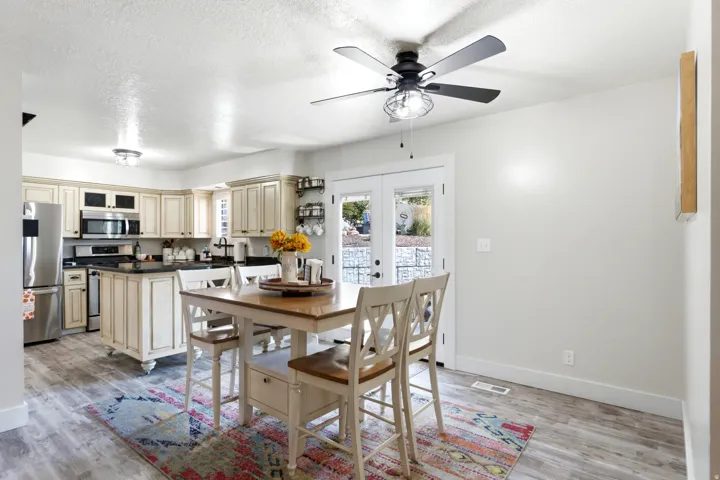 Kitchen with light wood-finish cabinetry, black countertops, stainless steel appliances, and a central island