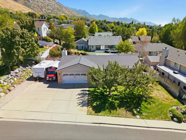 Front exterior with an attached two-car garage, concrete driveway, and mature landscaping