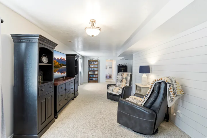 Carpeted floor, recessed lighting, and a white shiplap accent wall