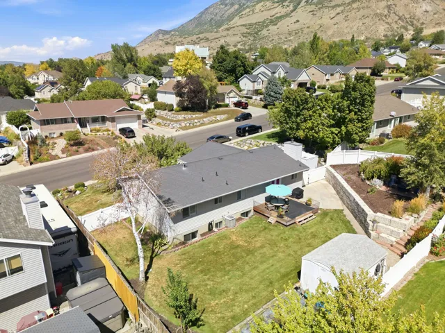 Expansive backyard featuring a manicured lawn, a wooden deck, and a storage shed