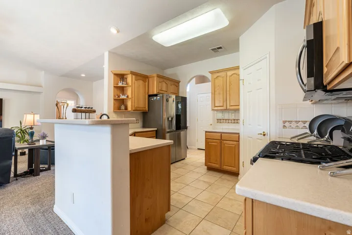 Kitchen featuring wood cabinetry, tile flooring, and light-toned countertops