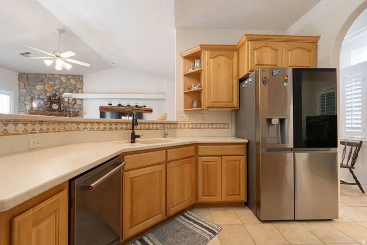 Kitchen featuring light wood cabinetry, a stainless steel refrigerator, and a built-in dishwasher