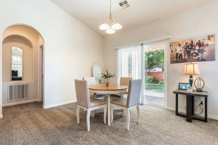Arched entryway leading to an interior hallway, sliding glass door to exterior, and vaulted ceiling